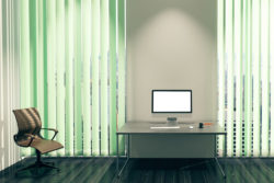 Vertical Blinds installed in an office space with work desk