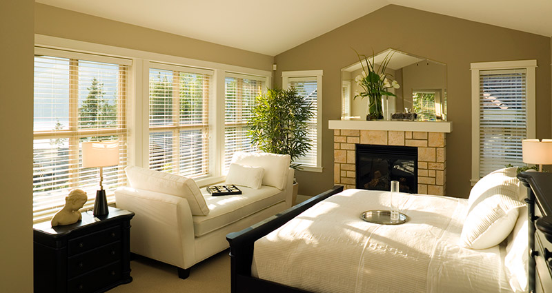 Faux wood window blinds let in lots of natural light in this bedroom