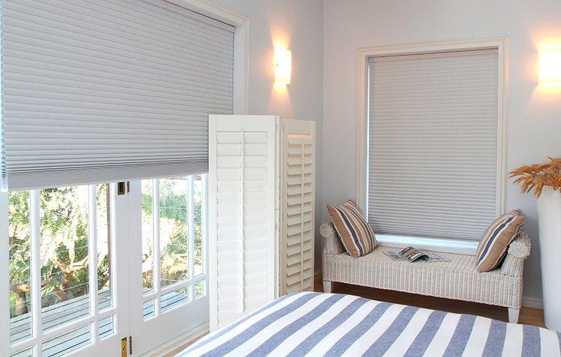 Honeycomb window blinds are great for blocking out light, like in this bedroom