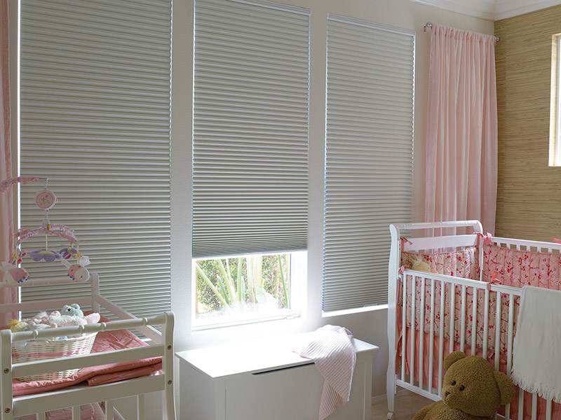 Honeycomb shades are the perfect custom blinds for this baby nursery