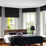 Dark roller shades from Oregon Blinds are prefect for blocking bright light in this bedroom