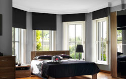 Dark roller shades from Oregon Blinds are prefect for blocking bright light in this bedroom