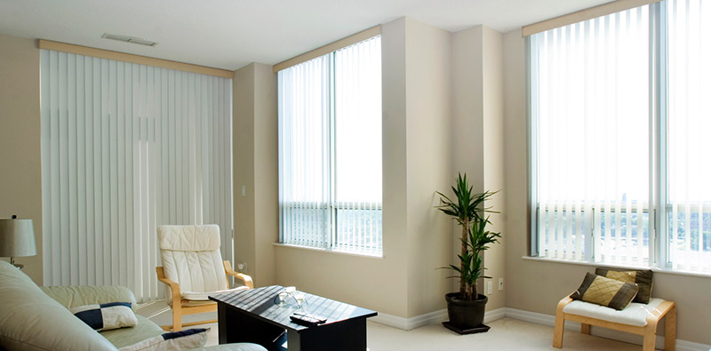 Open and closed sets of vertical blinds from Oregon Blinds show versatility in this warm living room