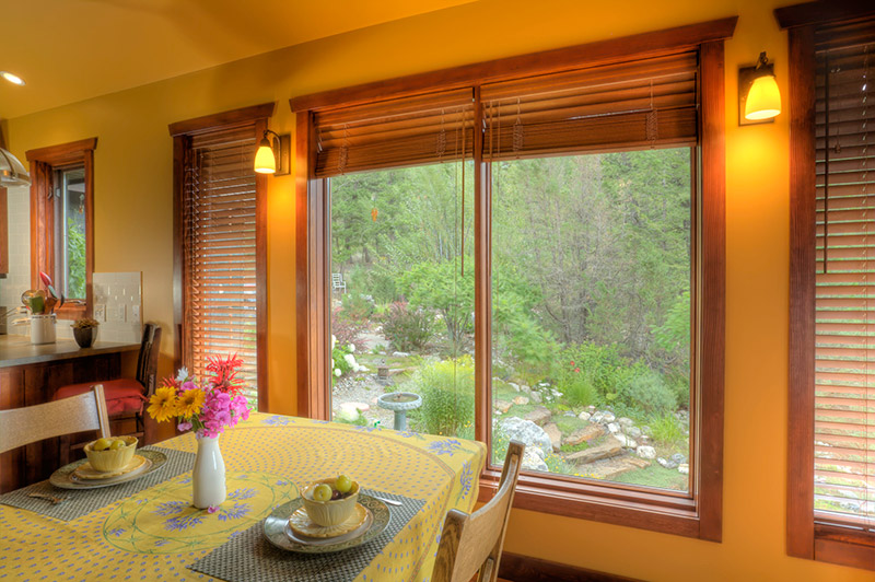 The wooden custom blinds in this dining space help tie in natural elements